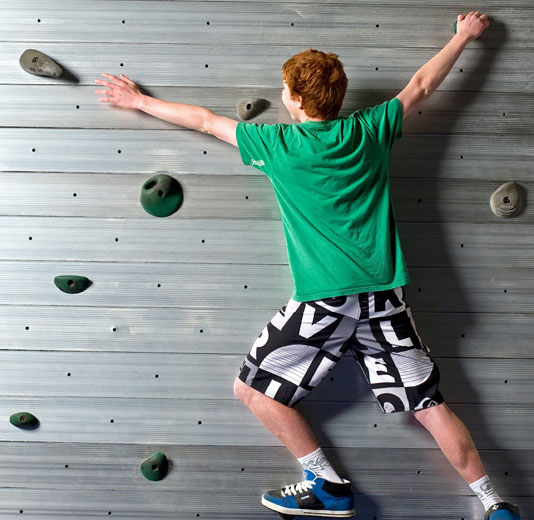 Redheaded Boy in Green Shirt on the Traversing Wall