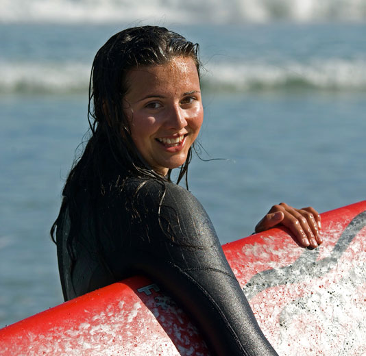 Smiling Surfer Girl with Red Surfboard