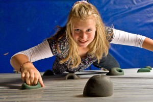 Girl Looking up to the top of the climbing wall